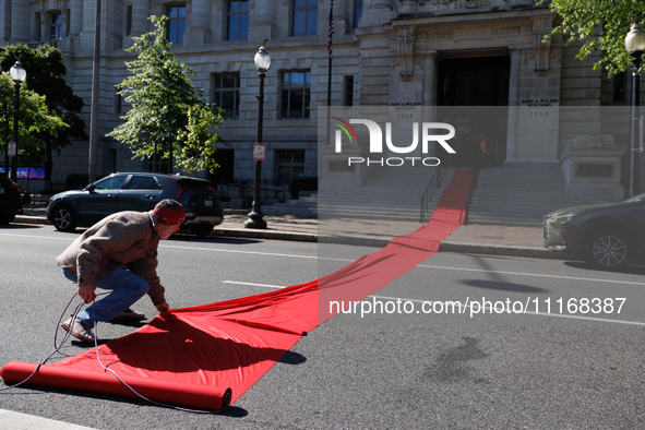 Climate activists with the Extinction Rebellion DC organization roll out a red carpet for Mayor Muriel Bowser during a protest outside of th...