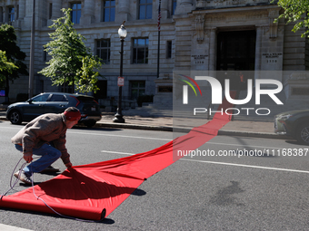 Climate activists with the Extinction Rebellion DC organization roll out a red carpet for Mayor Muriel Bowser during a protest outside of th...