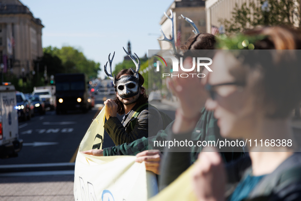 Climate activists with the Extinction Rebellion DC organization wear animal masks while marching to the John A. Wilson building in Washingto...