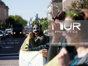 Climate activists with the Extinction Rebellion DC organization wear animal masks while marching to the John A. Wilson building in Washingto...