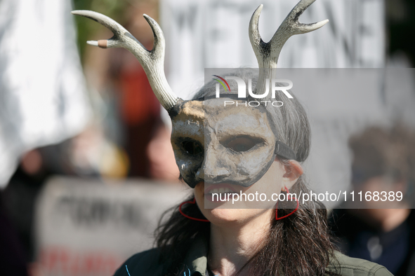 Climate activists with the Extinction Rebellion DC organization wear animal masks while marching to the John A. Wilson building in Washingto...