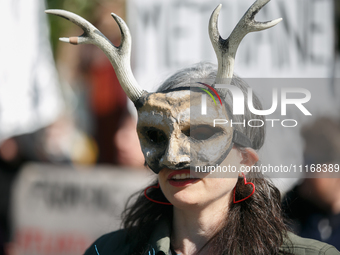 Climate activists with the Extinction Rebellion DC organization wear animal masks while marching to the John A. Wilson building in Washingto...