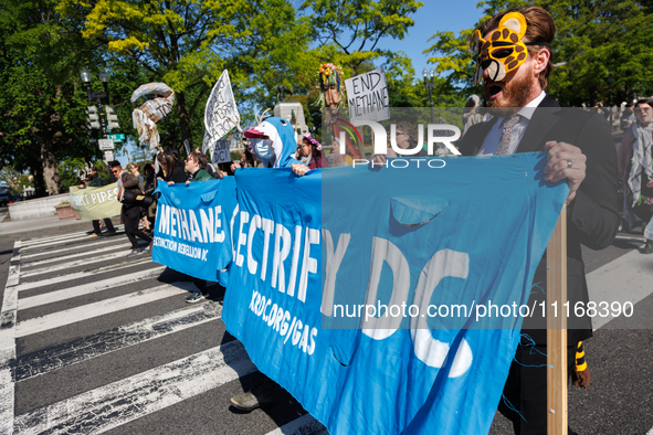 Climate activists with the Extinction Rebellion DC organization wear animal masks while marching to the John A. Wilson building in Washingto...