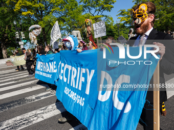 Climate activists with the Extinction Rebellion DC organization wear animal masks while marching to the John A. Wilson building in Washingto...