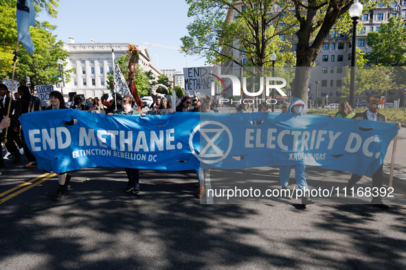 Climate activists with the Extinction Rebellion DC organization wear animal masks while marching to the John A. Wilson building in Washingto...