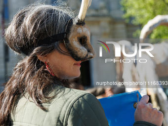 Climate activists with the Extinction Rebellion DC organization wear animal masks while marching to the John A. Wilson building in Washingto...