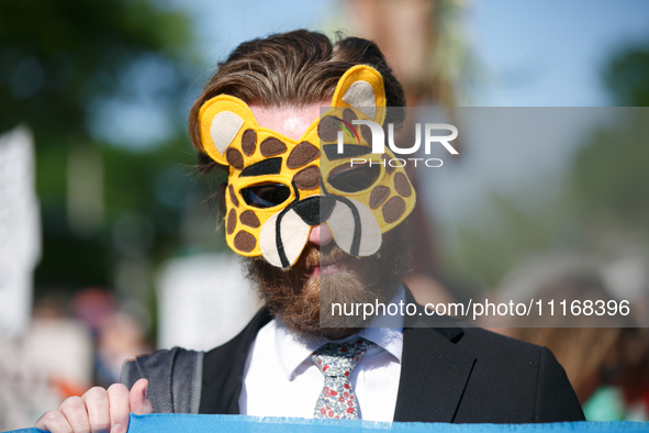 Climate activists with the Extinction Rebellion DC organization wear animal masks while marching to the John A. Wilson building in Washingto...