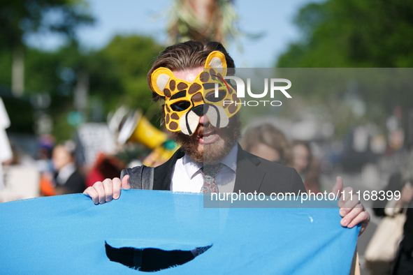 Climate activists with the Extinction Rebellion DC organization wear animal masks while marching to the John A. Wilson building in Washingto...