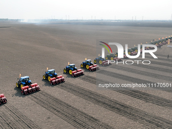 Seeders are lining up to sow seeds at a planting base in Shenyang, Liaoning Province, China, on April 22, 2024. (