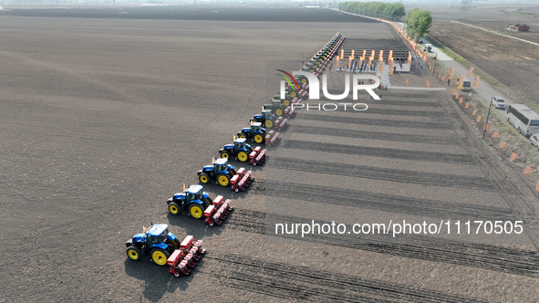 Seeders are lining up to sow seeds at a planting base in Shenyang, Liaoning Province, China, on April 22, 2024. 