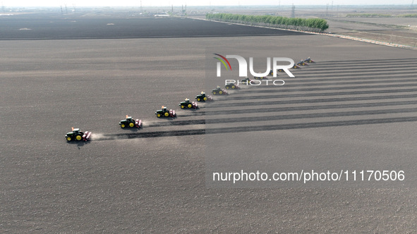 Seeders are lining up to sow seeds at a planting base in Shenyang, Liaoning Province, China, on April 22, 2024. 