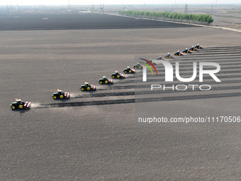 Seeders are lining up to sow seeds at a planting base in Shenyang, Liaoning Province, China, on April 22, 2024. (