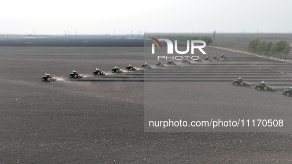 Seeders are lining up to sow seeds at a planting base in Shenyang, Liaoning Province, China, on April 22, 2024. 