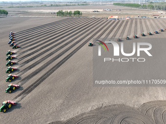 Seeders are lining up to sow seeds at a planting base in Shenyang, Liaoning Province, China, on April 22, 2024. (