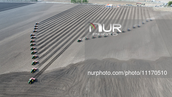 Seeders are lining up to sow seeds at a planting base in Shenyang, Liaoning Province, China, on April 22, 2024. 