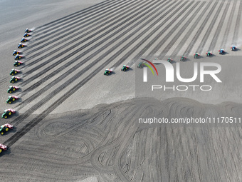 Seeders are lining up to sow seeds at a planting base in Shenyang, Liaoning Province, China, on April 22, 2024. (