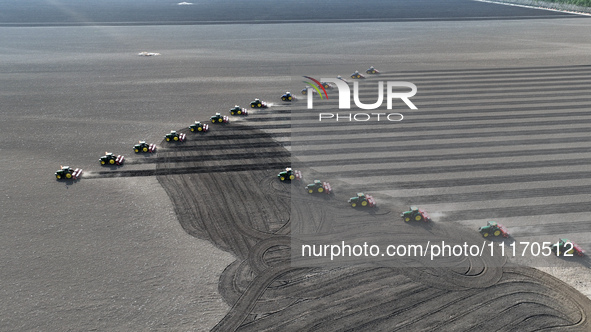 Seeders are lining up to sow seeds at a planting base in Shenyang, Liaoning Province, China, on April 22, 2024. 