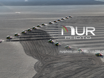 Seeders are lining up to sow seeds at a planting base in Shenyang, Liaoning Province, China, on April 22, 2024. (