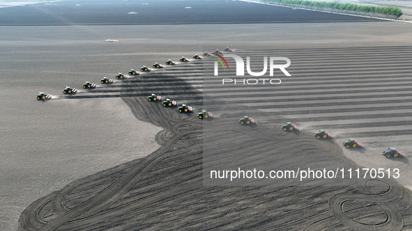 Seeders are lining up to sow seeds at a planting base in Shenyang, Liaoning Province, China, on April 22, 2024. 