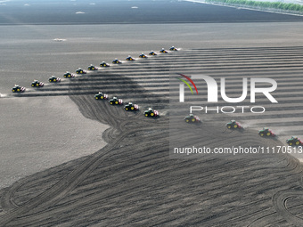 Seeders are lining up to sow seeds at a planting base in Shenyang, Liaoning Province, China, on April 22, 2024. (