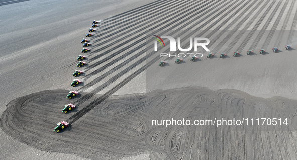 Seeders are lining up to sow seeds at a planting base in Shenyang, Liaoning Province, China, on April 22, 2024. 