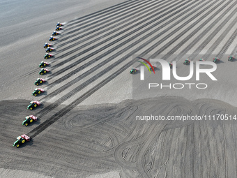 Seeders are lining up to sow seeds at a planting base in Shenyang, Liaoning Province, China, on April 22, 2024. (