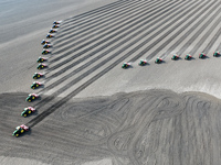 Seeders are lining up to sow seeds at a planting base in Shenyang, Liaoning Province, China, on April 22, 2024. (