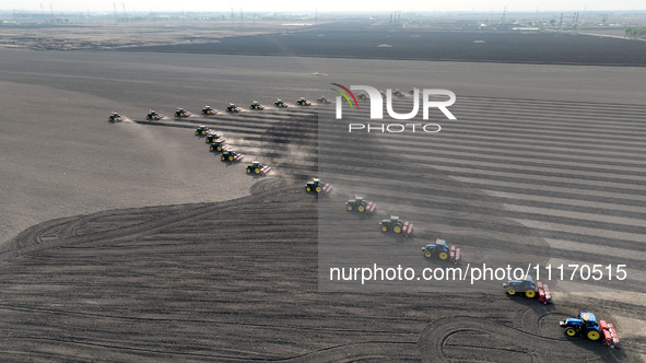 Seeders are lining up to sow seeds at a planting base in Shenyang, Liaoning Province, China, on April 22, 2024. 