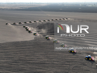 Seeders are lining up to sow seeds at a planting base in Shenyang, Liaoning Province, China, on April 22, 2024. (