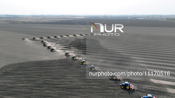 Seeders are lining up to sow seeds at a planting base in Shenyang, Liaoning Province, China, on April 22, 2024. 