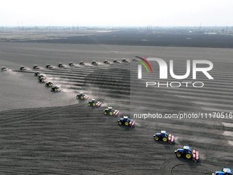 Seeders are lining up to sow seeds at a planting base in Shenyang, Liaoning Province, China, on April 22, 2024. (