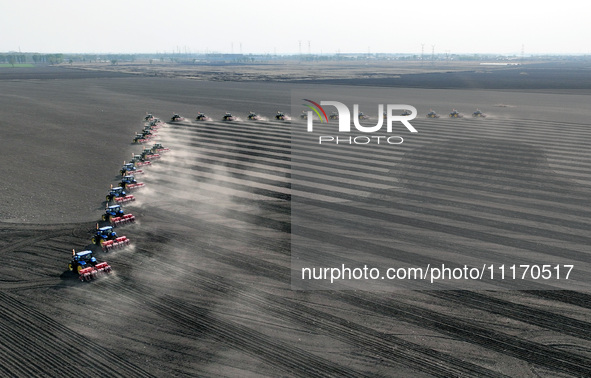 Seeders are lining up to sow seeds at a planting base in Shenyang, Liaoning Province, China, on April 22, 2024. 