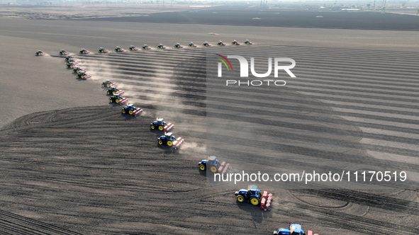 Seeders are lining up to sow seeds at a planting base in Shenyang, Liaoning Province, China, on April 22, 2024. 