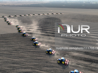 Seeders are lining up to sow seeds at a planting base in Shenyang, Liaoning Province, China, on April 22, 2024. (