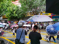 Parents are holding umbrellas to pick up students at the school gate as kindergarten classes resume at noon in Qingyuan, China, on April 23,...