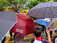 Parents are holding umbrellas to pick up students at the school gate as kindergarten classes resume at noon in Qingyuan, China, on April 23,...