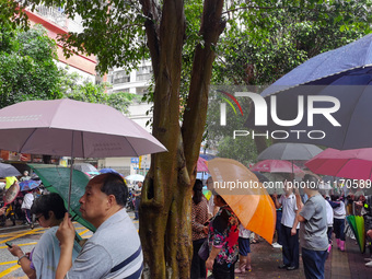 Parents are holding umbrellas to pick up students at the school gate as kindergarten classes resume at noon in Qingyuan, China, on April 23,...