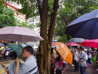 Parents are holding umbrellas to pick up students at the school gate as kindergarten classes resume at noon in Qingyuan, China, on April 23,...