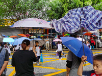 Parents are holding umbrellas to pick up students at the school gate as kindergarten classes resume at noon in Qingyuan, China, on April 23,...