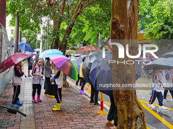 Parents are holding umbrellas to pick up students at the school gate as kindergarten classes resume at noon in Qingyuan, China, on April 23,...