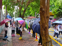 Parents are holding umbrellas to pick up students at the school gate as kindergarten classes resume at noon in Qingyuan, China, on April 23,...