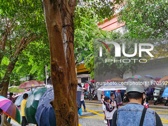 Parents are holding umbrellas to pick up students at the school gate as kindergarten classes resume at noon in Qingyuan, China, on April 23,...