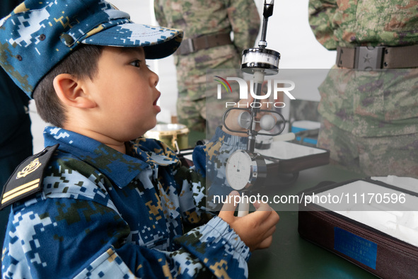 A child is learning to use naval equipment during an open ship day in Shanghai, China, on April 23, 2024. 