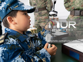 A child is learning to use naval equipment during an open ship day in Shanghai, China, on April 23, 2024. (