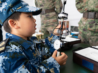 A child is learning to use naval equipment during an open ship day in Shanghai, China, on April 23, 2024. (