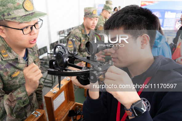 A visitor is learning to use naval equipment during the Open Ship Day in Shanghai, China, on April 23, 2024. 