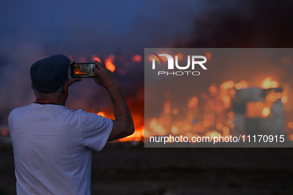 EDMONTON, CANADA - APRIL 22:
A local witnesses firefighters battling the flames that tore through Edmonton's historic Hangar 11 on Monday ev...