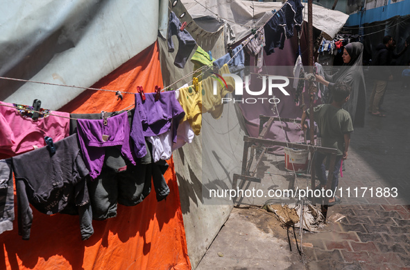 Displaced Palestinians are sheltering in a UNRWA-affiliated school after fleeing their homes due to Israeli strikes, amid the ongoing confli...