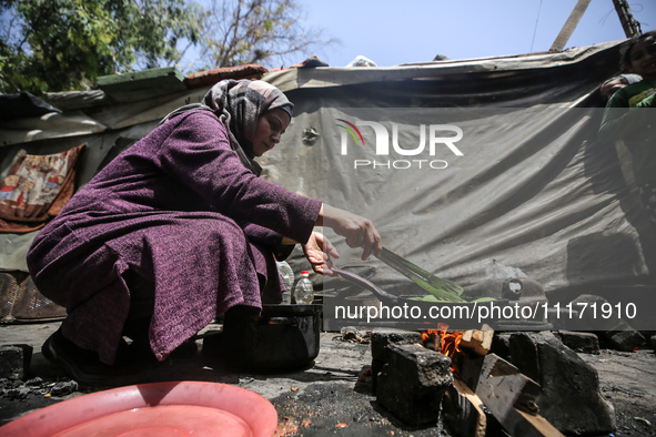 A displaced Palestinian woman, who has fled her home due to Israeli strikes, is looking on as she shelters in a UNRWA-affiliated school amid...