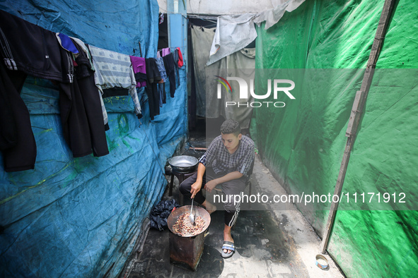 A displaced Palestinian man, who has fled his home due to Israeli strikes, is looking on as he shelters in a UNRWA-affiliated school amid th...